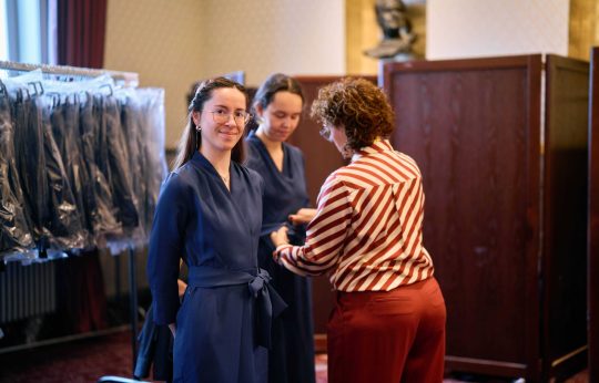 Coupeuse Liesbeth Haarbosch strikt de jurk van Mijntje Moll medewerkers horeca en garderobe